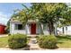 Charming single-Gathering home with a well-maintained lawn, mature tree, and a bright red front door at 745 S Utica St, Denver, CO 80219