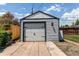 Image of a detached one-car garage with light gray siding and a concrete driveway at 745 S Utica St, Denver, CO 80219