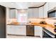 Well-lit kitchen with butcher block countertops, stainless appliances, and white cabinetry at 745 S Utica St, Denver, CO 80219