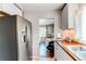 Well-lit kitchen featuring stainless steel appliances, wood countertop, and view to the dining area at 745 S Utica St, Denver, CO 80219
