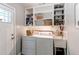 Functional laundry room with washer, dryer, utility sink, and built-in storage shelves at 745 S Utica St, Denver, CO 80219