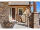 Covered front porch with stone columns, wood beam accents and a decorative bench at 17555 Lake Overlook Ct, Monument, CO 80132