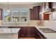 Kitchen featuring modern appliances, a white countertop, and dark cabinetry with natural light streaming through plantation shutters at 17555 Lake Overlook Ct, Monument, CO 80132