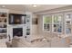 Bright living room with fireplace, built-in shelving, and shuttered windows at 17555 Lake Overlook Ct, Monument, CO 80132