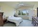 Bright bedroom featuring light walls, a ceiling fan, and natural light from multiple windows overlooking green trees at 8255 E 150Th Pl, Thornton, CO 80602
