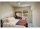 Bedroom with neutral decor, a wood dresser, and a bed with a colorful blanket at 8255 E 150Th Pl, Thornton, CO 80602