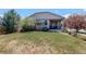 Charming front lawn with lush grass and mature trees adding to the home's curb appeal at 8255 E 150Th Pl, Thornton, CO 80602