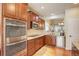 Modern kitchen featuring stainless steel appliances, granite countertops, and rich cherry wood cabinetry at 8255 E 150Th Pl, Thornton, CO 80602