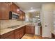 Spacious kitchen with stainless steel appliances, granite countertops, and dark wood cabinets for storage at 8255 E 150Th Pl, Thornton, CO 80602
