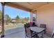 Covered patio area featuring a table, chairs, and a grill overlooking the yard at 8255 E 150Th Pl, Thornton, CO 80602