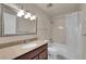 Classic bathroom features a tile shower, granite vanity, updated fixtures, and mirror at 10116 Quivas St, Thornton, CO 80260