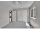 Bright bedroom with soft carpet, and closet with sliding doors plus a large window at 10116 Quivas St, Thornton, CO 80260