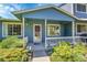Inviting covered front porch with a cozy entrance, complemented by mature landscaping at 10116 Quivas St, Thornton, CO 80260
