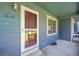 Close-up of a charming covered front porch with a red door and well-maintained details at 10116 Quivas St, Thornton, CO 80260