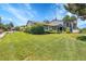 Expansive front yard featuring lush green grass, mature trees, and a well-maintained blue home at 10116 Quivas St, Thornton, CO 80260