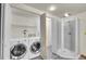 Functional laundry room with modern washer and dryer, and a shower stall, offering convenience and practicality at 10116 Quivas St, Thornton, CO 80260