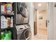 Convenient laundry area with stacked washer/dryer and storage shelves adjacent to a tiled bathroom at 658 S Dudley St, Lakewood, CO 80226