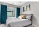 Bedroom with neutral walls, plush carpet, and large window with blue curtains at 4922 Lowell Blvd # 2, Denver, CO 80221