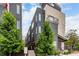 Contemporary townhome with gray stucco, modern windows, and mature trees in a vibrant urban setting at 4922 Lowell Blvd # 2, Denver, CO 80221