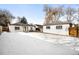 Spacious backyard with a detached garage, white painted brick, and a full snow cover at 2610 Poplar St, Denver, CO 80207
