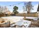 The backyard features patio, snow, trees, and string lights at 2610 Poplar St, Denver, CO 80207