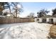 Large backyard, partially covered in snow, with a wooden fence at 2610 Poplar St, Denver, CO 80207