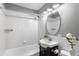 Well-lit bathroom featuring a white tiled tub/shower, elegant vanity, and updated fixtures at 2610 Poplar St, Denver, CO 80207