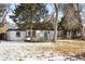 Charming single-story home with a well-maintained front yard and mature trees in winter at 2610 Poplar St, Denver, CO 80207