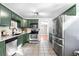 Bright kitchen features stainless steel appliances, green cabinets, and light countertops at 2610 Poplar St, Denver, CO 80207