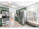 Green kitchen with stainless steel appliances, tile floors, and bright lighting at 2610 Poplar St, Denver, CO 80207