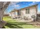 Expansive backyard with a covered patio, stone flooring, grill, and well-maintained lawn at 20630 E Ithaca Pl, Aurora, CO 80013