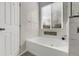 Bathroom with a jacuzzi tub, tiled walls, and a window that offers natural light and scenic views at 20630 E Ithaca Pl, Aurora, CO 80013