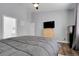 Bedroom with gray walls, a queen-sized bed, hardwood floors, and a mounted TV for convenient entertainment at 20630 E Ithaca Pl, Aurora, CO 80013