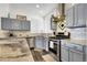 The renovated kitchen has stainless appliances, gray cabinets, marble backsplash, and granite countertops at 20630 E Ithaca Pl, Aurora, CO 80013