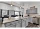 Open-concept kitchen features an island with granite countertops, gray cabinets, and seamless integration with the dining and living areas at 20630 E Ithaca Pl, Aurora, CO 80013