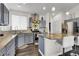 The kitchen boasts stainless steel appliances, gray cabinets, granite countertops and a functional island with bar stool seating at 20630 E Ithaca Pl, Aurora, CO 80013
