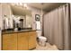 Cozy bathroom featuring granite countertop, neutral walls, and a shower with decorative gray curtain at 1700 Bassett St # 2117, Denver, CO 80202