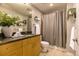 Well-lit bathroom with granite countertops, decorative plants, and a shower with a gray curtain at 1700 Bassett St # 2117, Denver, CO 80202