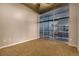 Clean, empty bedroom features carpet flooring and a large window with city views at 1700 Bassett St # 2117, Denver, CO 80202