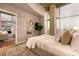 Relaxing bedroom featuring neutral colors, a large window offering city views, and an open doorway at 1700 Bassett St # 2117, Denver, CO 80202