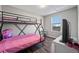 Bedroom featuring a bunkbed and large window at 55429 E 31St Ave, Strasburg, CO 80136