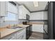 Efficient kitchen with white cabinets, black appliances, and a functional layout at 55429 E 31St Ave, Strasburg, CO 80136