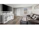 Inviting living room with stylish gray walls, entertainment center, and a comfortable leather sofa at 55429 E 31St Ave, Strasburg, CO 80136