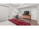 Well-lit bedroom featuring a bed, desk, and a dresser with mounted TV at 5761 W 50Th Ave, Denver, CO 80212