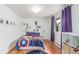 Bright bedroom with colorful superhero themed bedding, decor and hardwood floors at 5761 W 50Th Ave, Denver, CO 80212