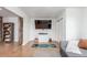 Cozy living area with a gray sofa, mounted TV, shelving, and a yoga mat at 5761 W 50Th Ave, Denver, CO 80212