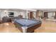 Spacious recreation room featuring a pool table, lounge area, and stone fireplace at 5761 W 50Th Ave, Denver, CO 80212