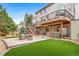 Multi-tiered backyard featuring an entertainment space, lush lawn, and a hot tub at 9928 Sylvestor Rd, Highlands Ranch, CO 80129
