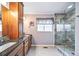 The primary bathroom features double sinks, granite countertops, wood cabinets, and a walk-in shower at 9928 Sylvestor Rd, Highlands Ranch, CO 80129