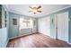 This bedroom features hardwood floors, ceiling fan, and a window with curtains at 9928 Sylvestor Rd, Highlands Ranch, CO 80129